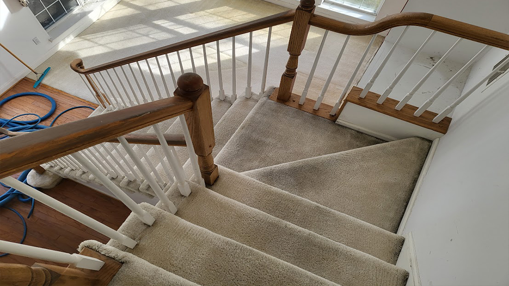 Stair view of living room gives buyer idea of potential after carpet and flooring replaced
