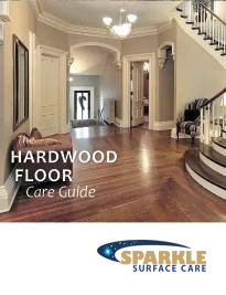 Elegant entry hall with dark hardwood floor and curved staircase; cover reads Hardwood Floor Care Guide with Sparkle Surface Care logo nearby.