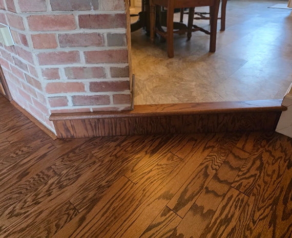 Engineered hardwood kitchen stair nosing and riser refinished to blend with floor. Finished hallway view