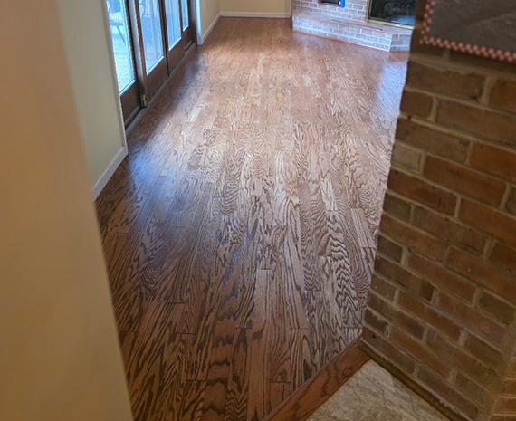 View from kitchen of refinished engineered hardwood floor with custom stain match.