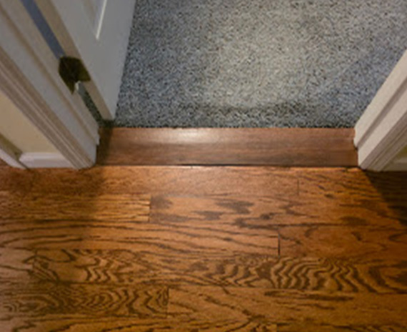 Refinished engineered hardwood bedroom threshold blended with surrounding wood floor.