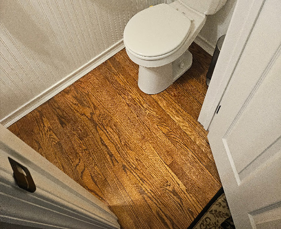 Yellowed hardwood bathroom floor before refinishing in Tabernacle, NJ