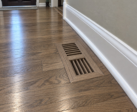 Refinished hardwood floor with custom flush-mount wood HVAC vent in Tabernacle, NJ. Caption: