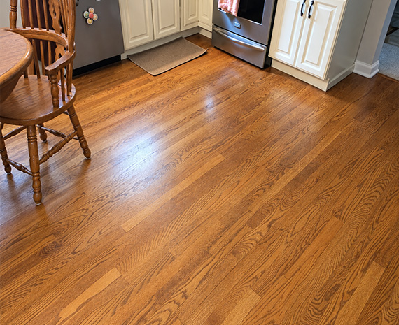 Hardwood kitchen floor with aged amber finish before refinishing in Tabernacle, NJ.