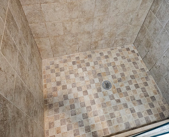 Walk-in shower with mosaic tile floor and discolored grout before professional shower cleaning and restoration in Cape May County, NJ.